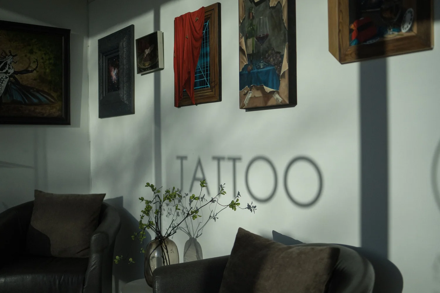 Art Realm gallery wall with paintings and tattoo signage